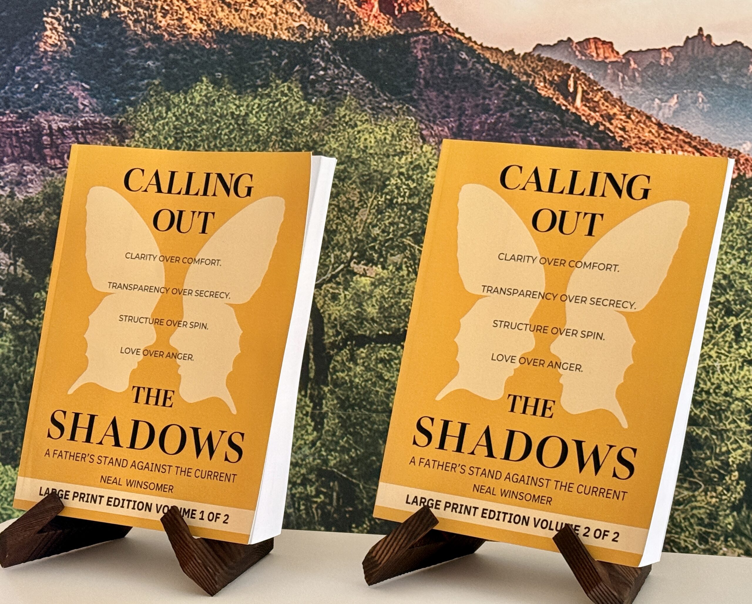 Calling Out the Shadows large print editions, both volumes standing on wooden book stands, Volume 1 of 2 and Volume 2 of 2, set in 18-point type, by Neal Winsomer.